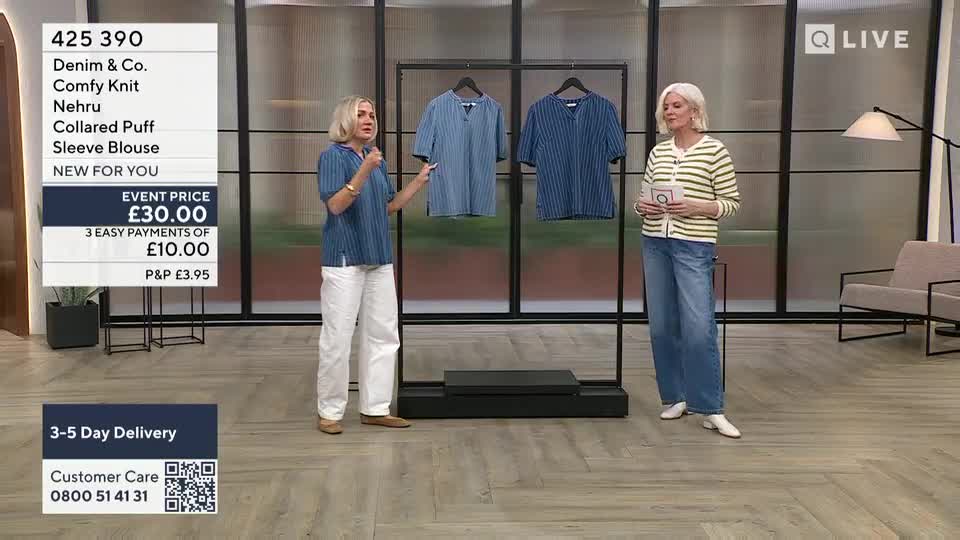 Two women stand on a studio floor, one presenting a blue striped blouse as the other listens. The QVC Extra screen displays product details and pricing information. Two women stand on a studio floor, one presenting a blue striped blouse as the other listens. The QVC Extra screen displays product details and pricing information.