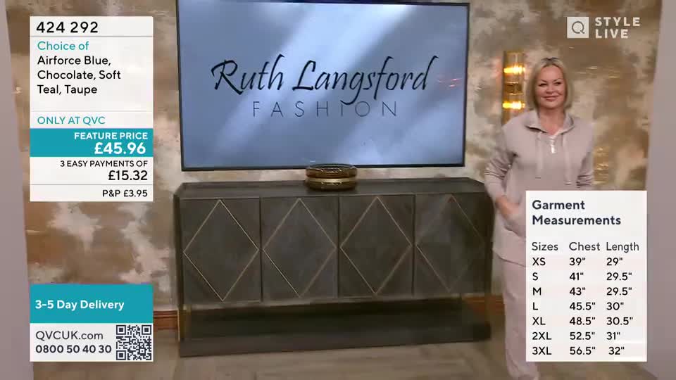 A woman in a pale pink tracksuit smiles as she stands beside a display cabinet. On the screen behind her, the "Ruth Langsford Fashion" logo is visible.
