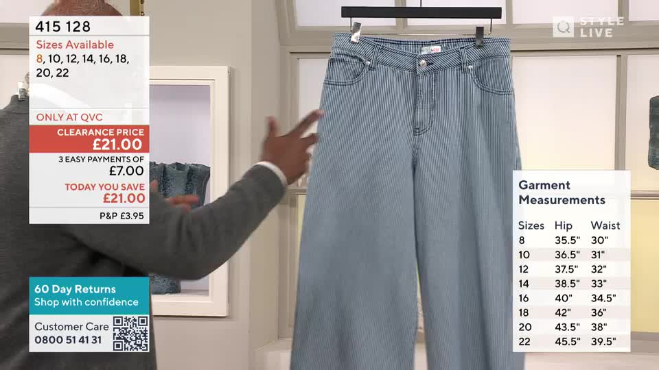 A man gestures towards a pair of wide-leg, pinstripe denim trousers hanging on display. A QVC-style graphic overlays the scene, detailing product information and garment measurements.