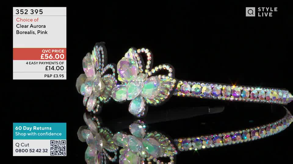 A sparkly hairband, adorned with iridescent stones and floral designs, rests on a reflective surface. The QVC logo and product details are displayed in the corner.