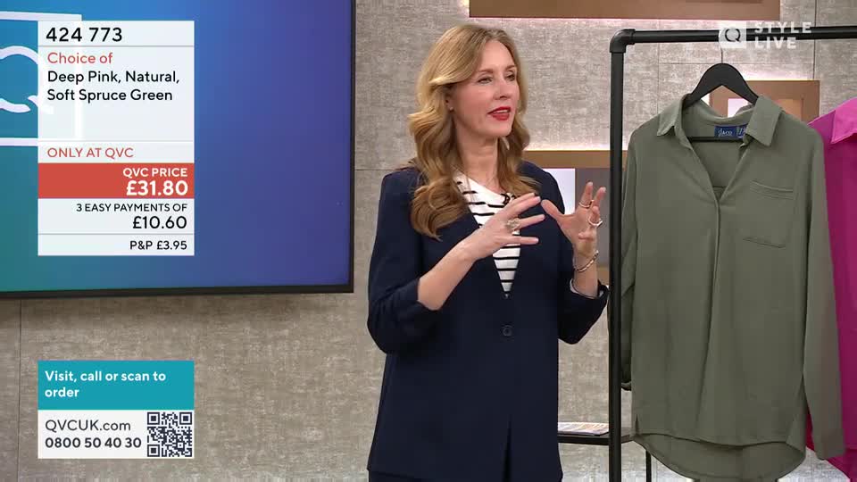 A woman gestures with her hands as she talks, standing in front of a display of clothing. A screen behind her shows product details and ordering information.