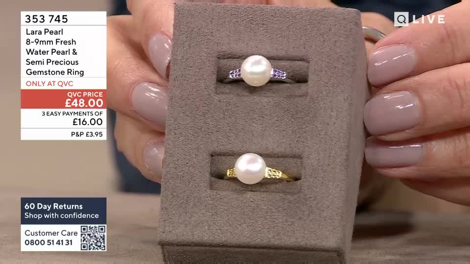 A hand with neatly painted nails gently holds a display stand showcasing two pearl rings. The top ring is silver with a pearl and small purple stones, while the bottom one is gold with a pearl and textured detail.