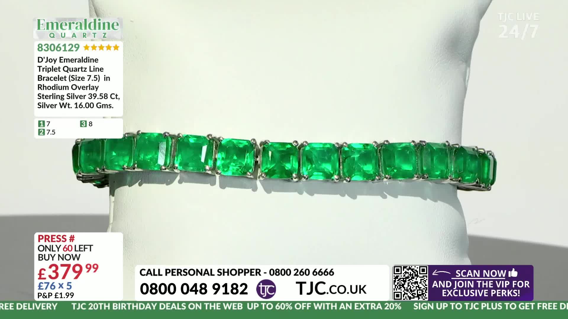 A line of vibrant green emeralds, set in silver, rests on a white display. The bracelet is presented on TJC, a UK-based shopping channel.