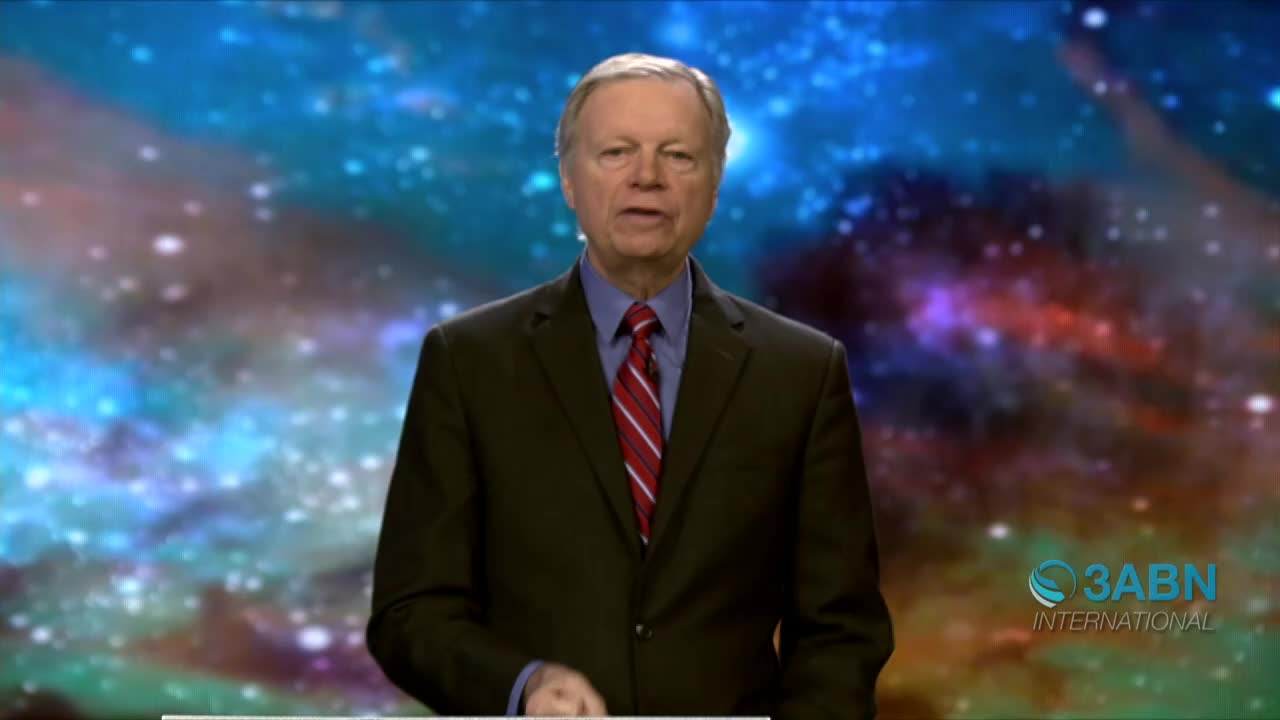 A man in a dark suit and red tie stands before a backdrop of swirling space. The logo for 3ABN International is visible in the lower right corner.
