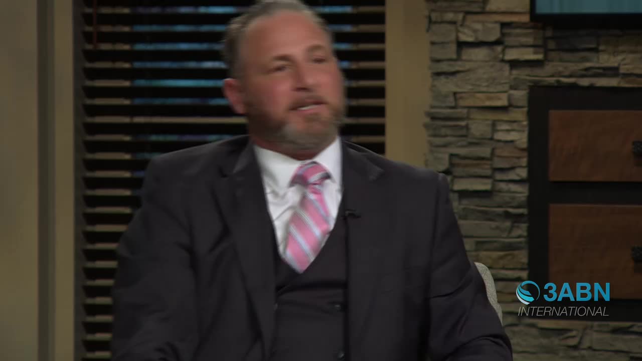 A man in a suit and a pink-striped tie speaks animatedly. The 3ABN International logo is visible in the lower right corner.