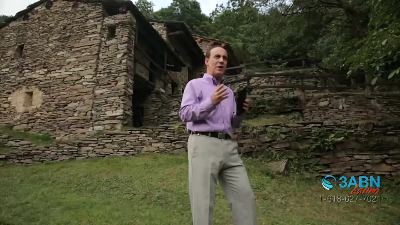 A man in a purple shirt stands in front of a stone building, gesturing with his hands as he speaks. The 3ABN Latino logo is in the corner of the screen.
