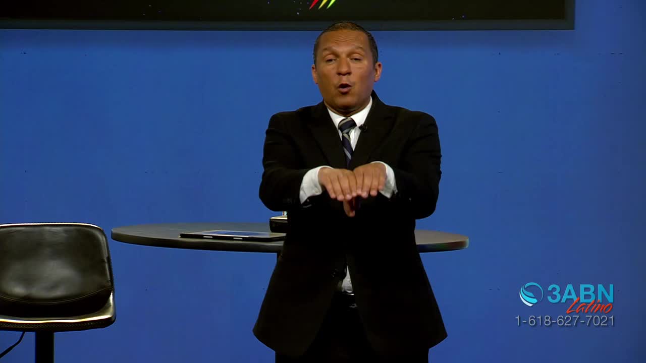A man in a suit gestures with his hands, palms down, as if presenting something. The 3ABN Latino logo is visible in the corner.
