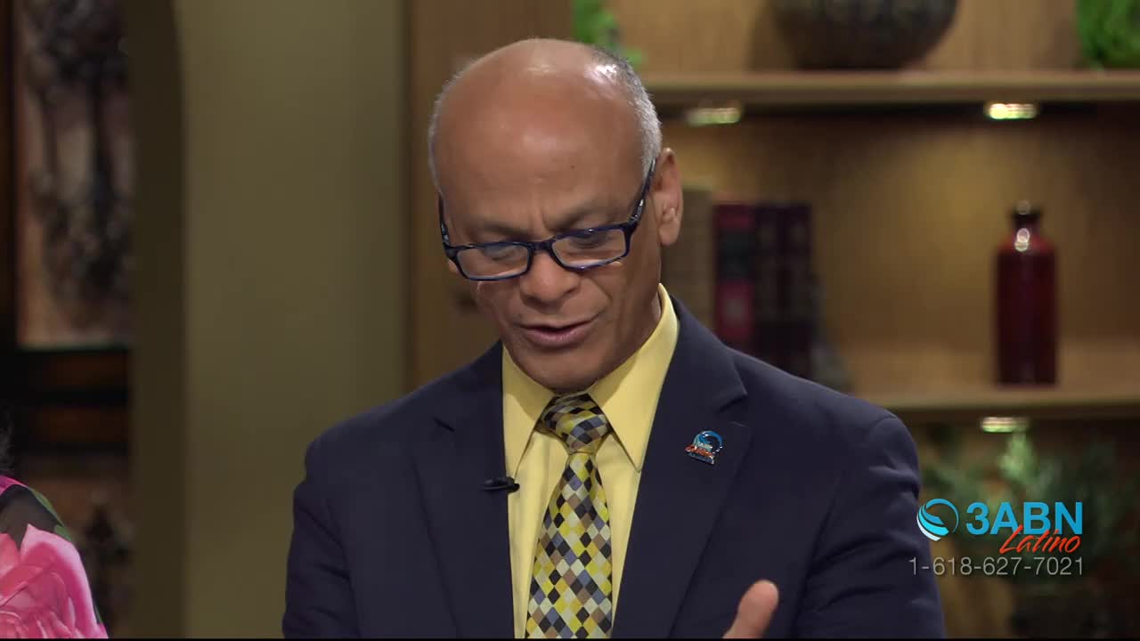 A man in a suit and tie speaks, his glasses reflecting the studio lights. A logo for 3ABN Latino appears in the corner of the screen.