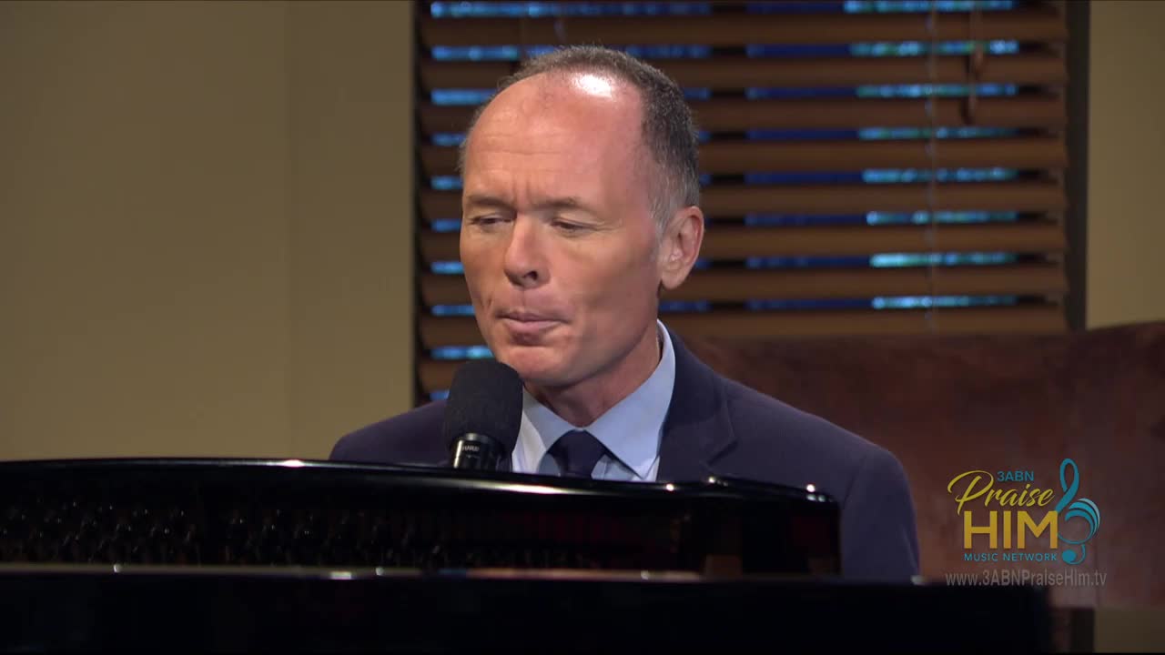 The man in the suit is singing into a microphone while seated at a piano. He's on the 3ABN Praise Him Music Network, and the logo is visible in the corner.
