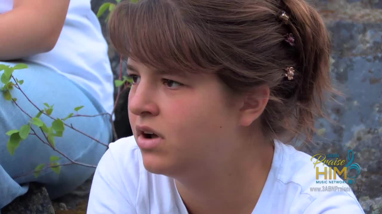 A young woman with brown hair and a white shirt is looking off-camera, her mouth slightly open. The 3ABN Praise Him Music Network logo is visible in the corner.
