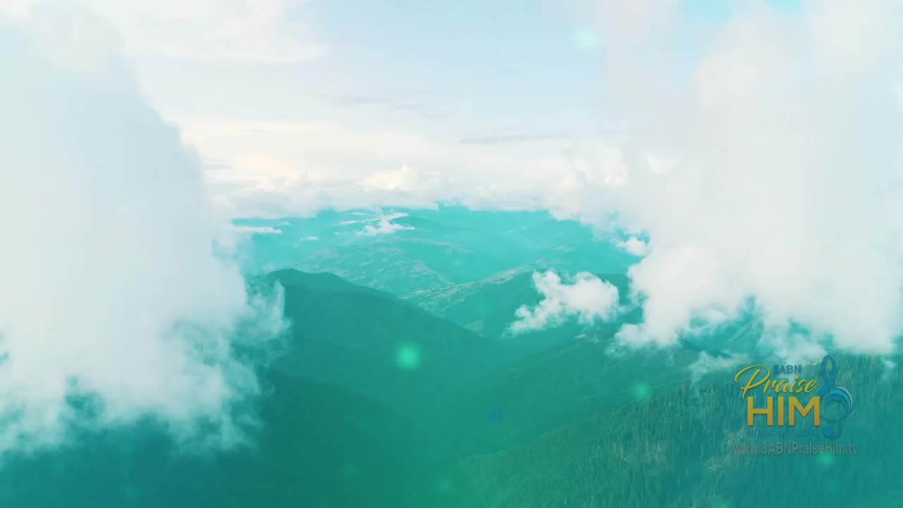 Clouds drift across a mountain range, partially obscuring the peaks. The logo for 3ABN Praise Him Music Network is visible in the lower right corner.
