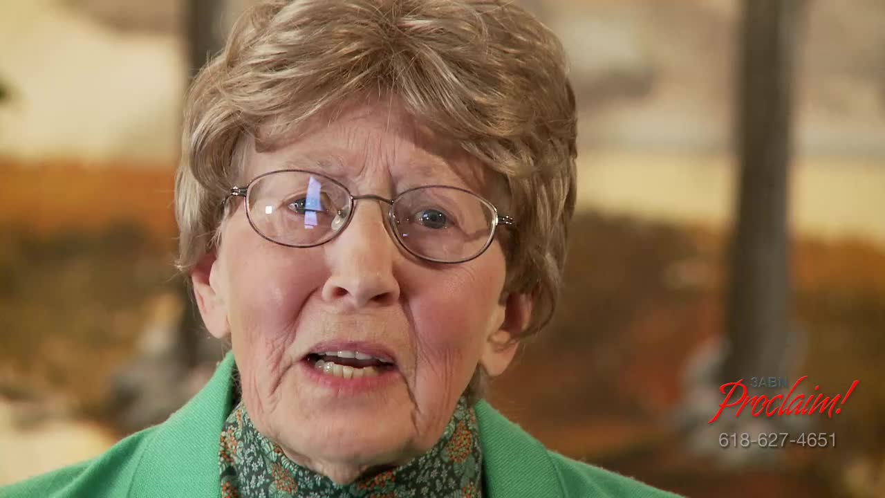 A woman with glasses and a green jacket is speaking, her mouth open as she forms words. The 3ABN Proclaim! logo is in the corner.
