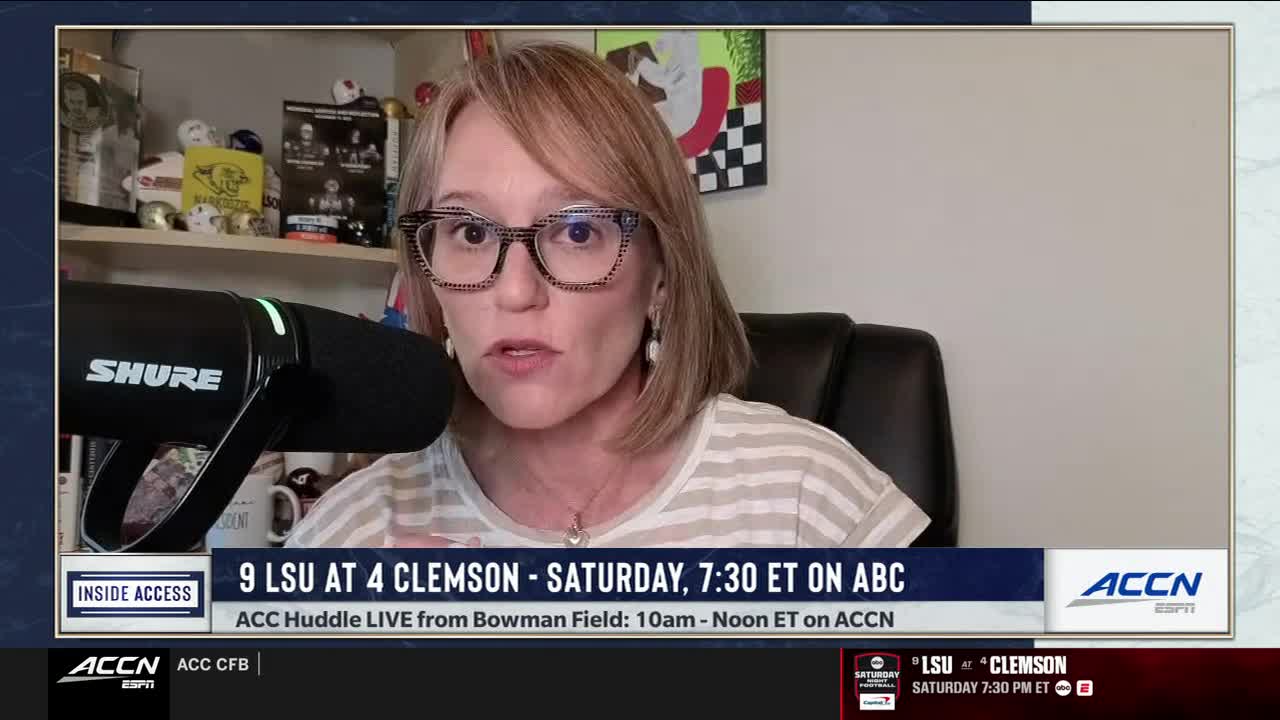 A woman wearing glasses and a striped shirt speaks directly into a black microphone, framed by a "SHURE" logo. The ACC Network graphic at the bottom promotes a college football game between LSU and Clemson.
