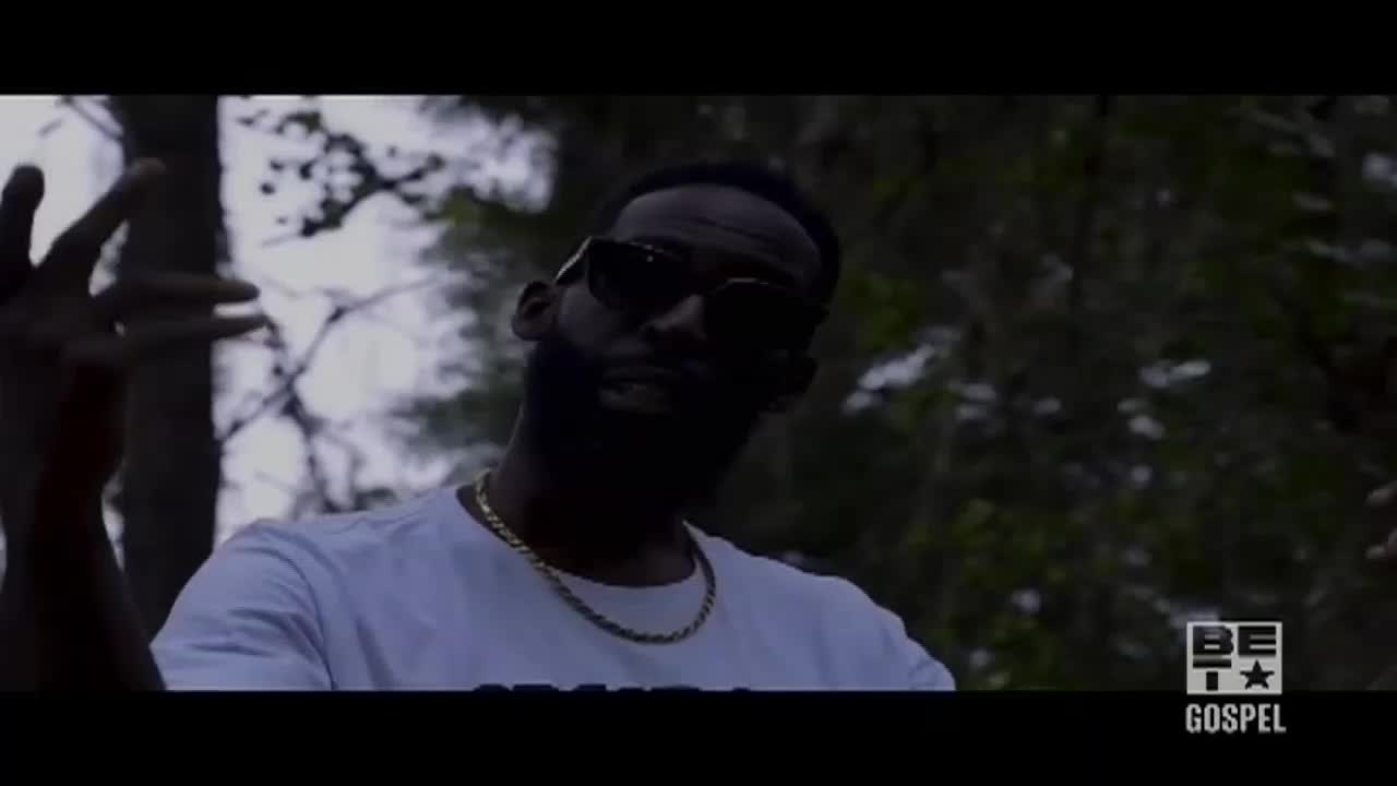 A man in sunglasses gestures with his hands in front of a blurred forest background. The BET Gospel logo is visible in the bottom right corner.
