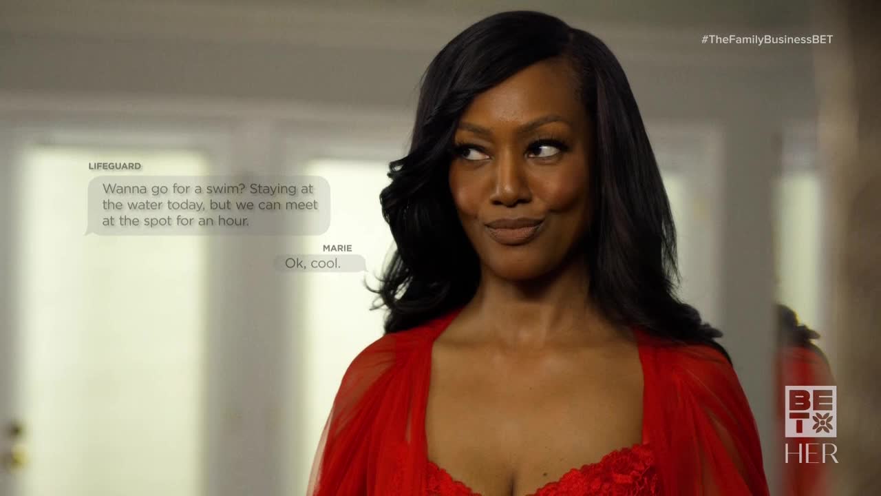 Marie, in a red robe, looks off to the side with a slight smile. A text bubble on the screen shows a message from "Lifeguard" asking her to swim.
