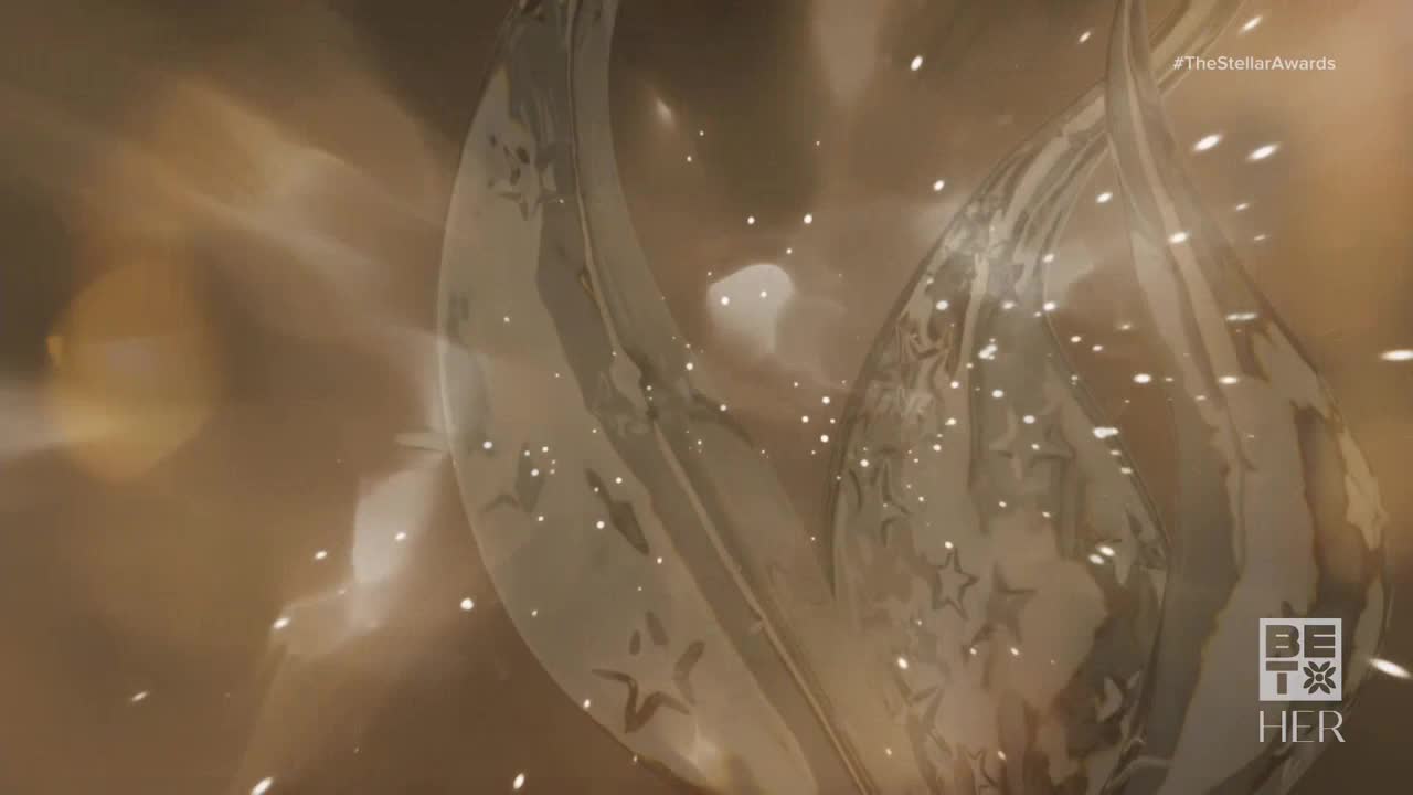 A translucent, star-patterned shape shimmers, reflecting light. Tiny white particles drift across the screen, suggesting a celebratory mood from BET Her.
