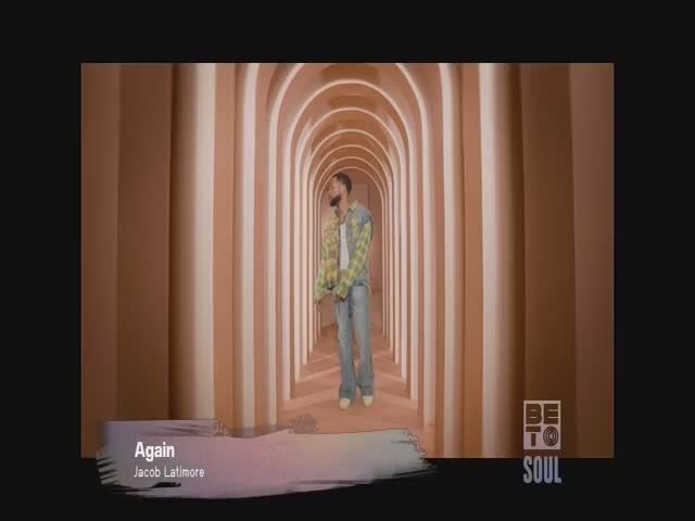 Jacob Latimore stands in a long, arched hallway, his figure centered in the frame. The BET Soul logo sits in the corner as he performs his song, "Again."
