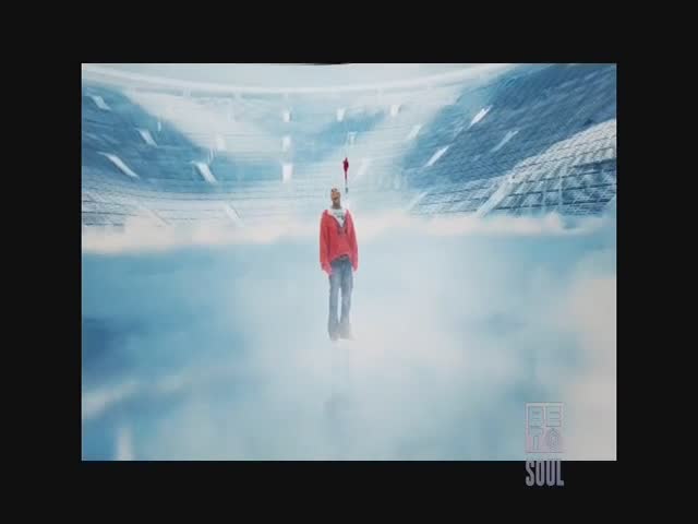 A man in a red jacket floats in a cloudy, stadium-like space. Above him, a small red flag waves, and the BET Soul logo sits in the corner.
