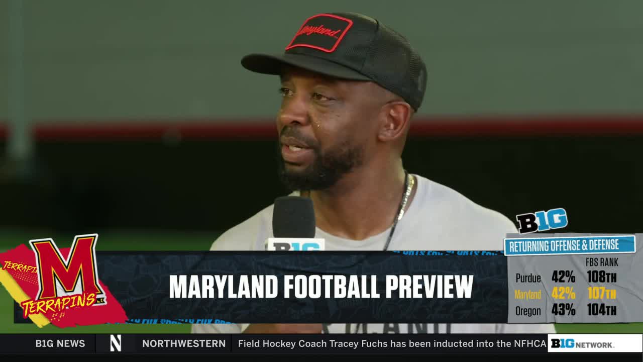A man wearing a Maryland hat speaks into a microphone, likely for the Big Ten Network. Graphics on the screen show a Maryland Football Preview with team stats.
