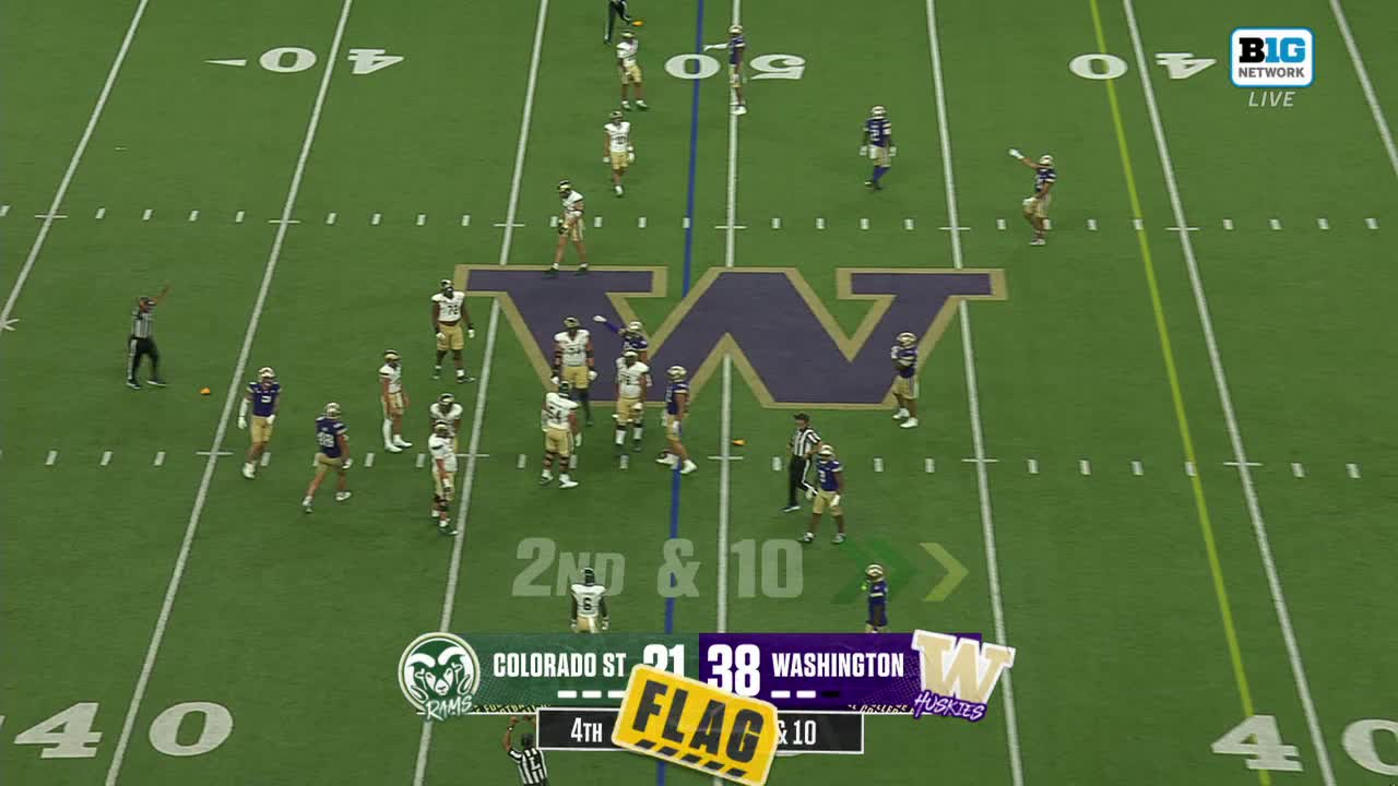 A referee throws a penalty flag, and the players on the field react. The Washington Huskies are up against Colorado State, and the game is being broadcast on the Big Ten Network.
