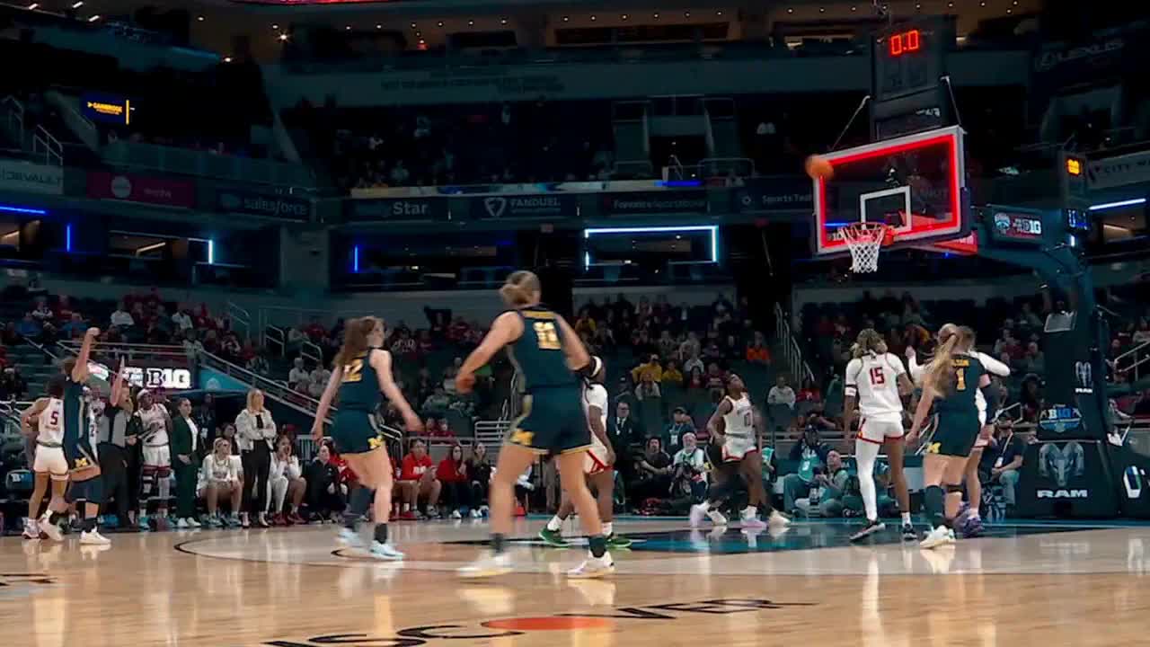 The ball arcs toward the hoop as a player in a navy jersey raises her arm in celebration. The score clock shows the final seconds of a Big Ten Network basketball game.
