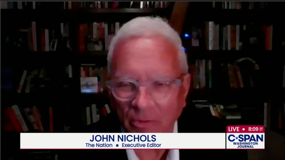 John Nichols, Executive Editor of The Nation, is on C-SPAN's Washington Journal, speaking from what looks like a home office. Behind him, a wall of books fills the space.
