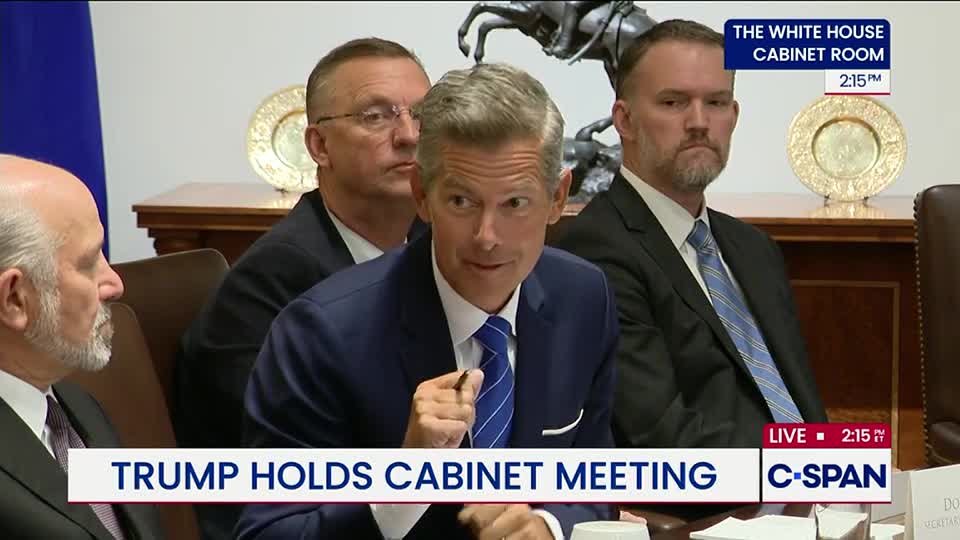 A man in a blue suit gestures with his right hand while speaking at a table. The C-SPAN graphic confirms this is a live broadcast from a White House Cabinet meeting.
