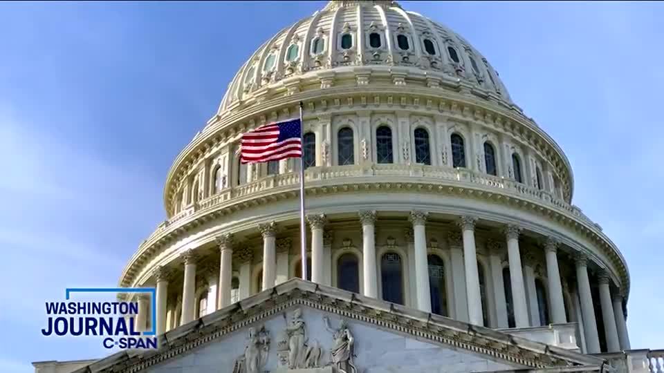 The Capitol dome rises against a clear, blue sky, with the American flag waving gently in the breeze. A "Washington Journal" graphic from C-SPAN is visible in the lower left corner.
