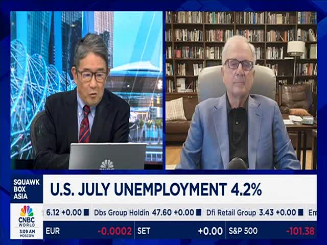 Two men in suits are on a split screen, one speaking while looking at a laptop, the other seated and listening. The CNBC World graphic displays the U.S. July unemployment rate.
