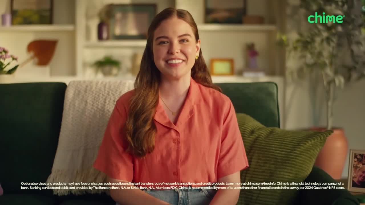 A young woman in an orange shirt smiles directly at the camera, sitting on a green couch. The "Chime" logo is visible in the top right corner, and the setting suggests a commercial on Comedy Central in the United States.

