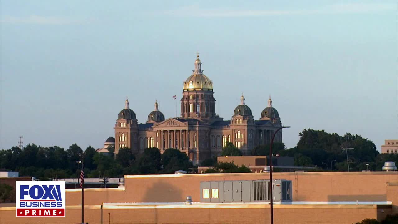 The Iowa State Capitol building stands tall against a clear sky, its golden dome catching the light. A Fox Business Network graphic is in the lower left corner, likely reporting from the United States.
