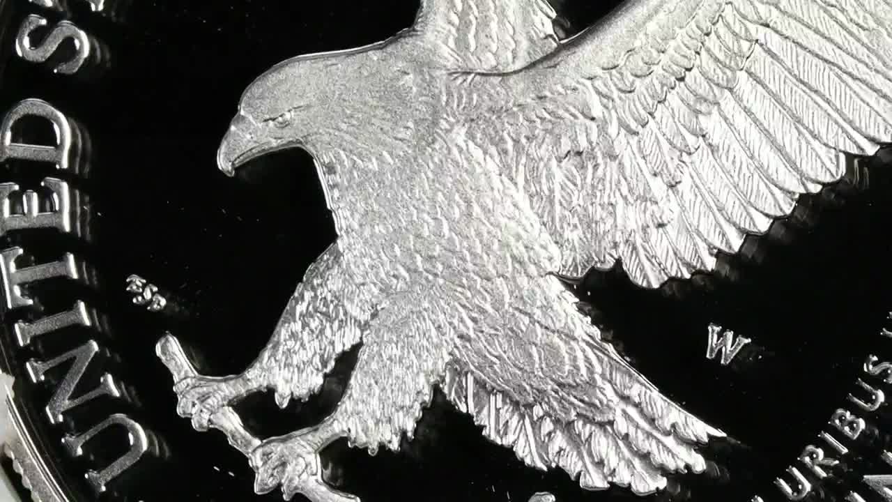 The eagle's detailed feathers and sharp beak are etched onto a coin, the design catching the light. The words "United States" are visible along the coin's edge, likely highlighting a segment of the American economy on Fox Business Network.
