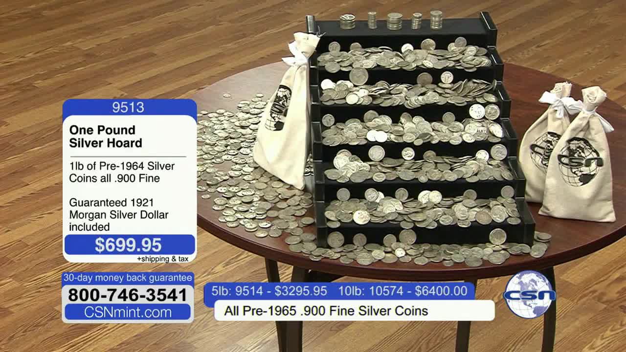 A table on Fox Business Network holds a tiered display overflowing with silver coins, along with several bags of them. A price tag on the left advertises a "Silver Hoard" for sale.
