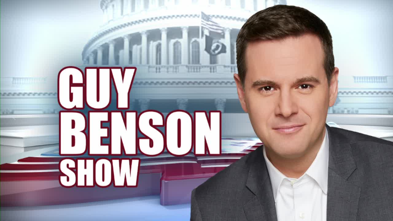 A man in a suit stands in front of a graphic of the U.S. Capitol. The words "GUY BENSON SHOW" appear in large, bold letters beside him.