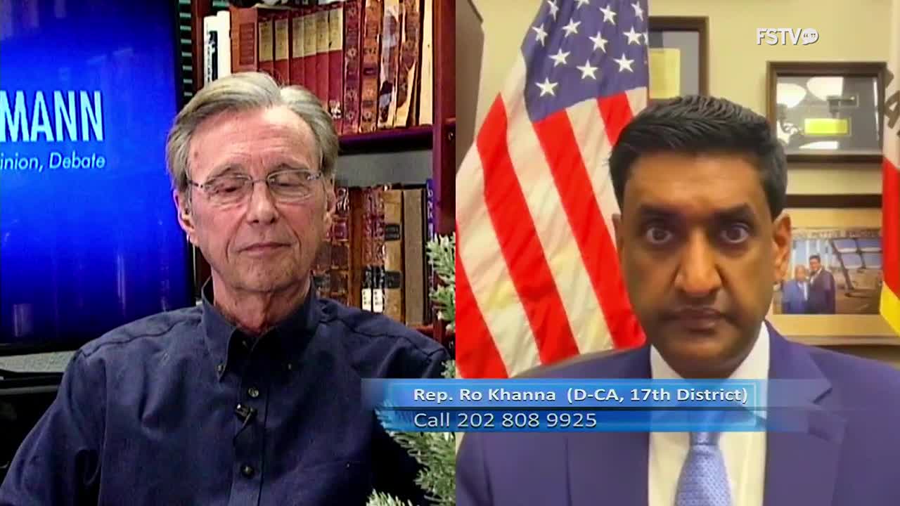 On Free Speech TV, two men are on screen, one in a blue shirt, the other in a suit, with the American flag visible behind the latter. A graphic identifies Congressman Ro Khanna of California.

