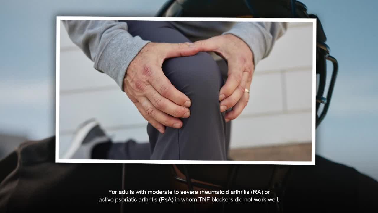 A man kneels, his hands clasped around his knee. His skin shows some redness, and a gold ring glints on his finger.
