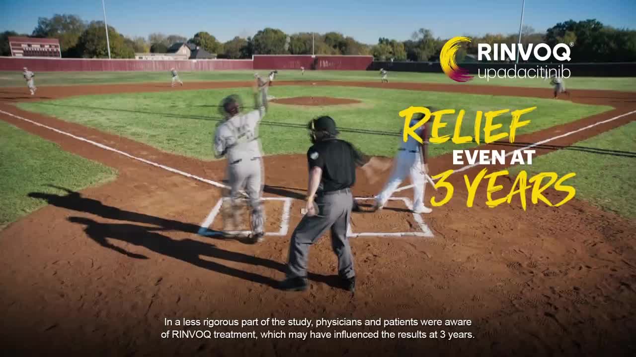 A batter swings, and the umpire signals a call as the runner heads for first base. The players appear blurred, as if the camera captured them mid-motion on the baseball field.
