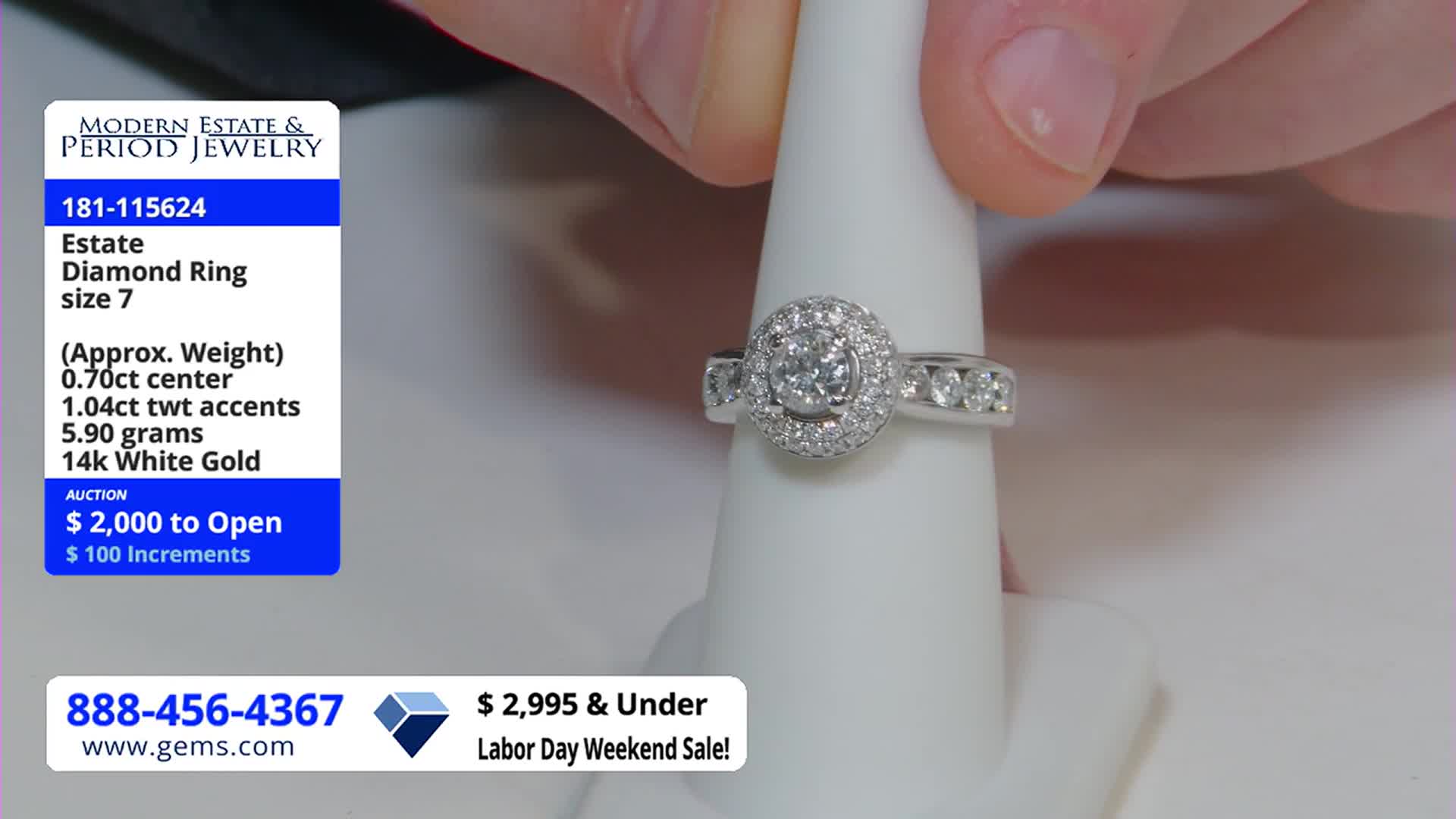 A hand gently holds a diamond ring, showcasing the sparkling stones on a white display. The ring is presented on a Gem Shopping Network broadcast, with details about its weight and auction price visible on screen.
