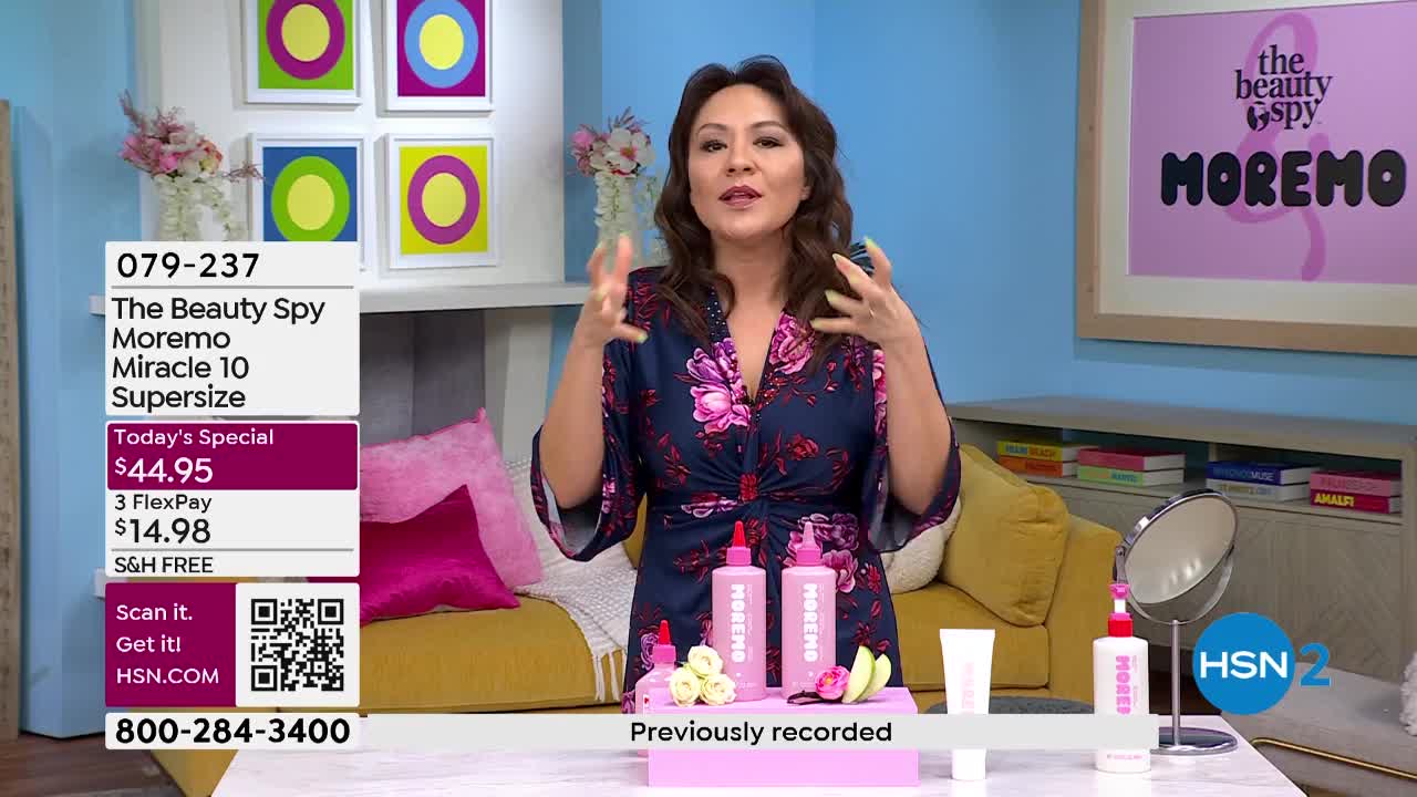 A woman in a floral robe gestures enthusiastically while presenting two pink bottles of Moremo Miracle 10 Supersize. The HSN2 logo and product information are visible on the screen.