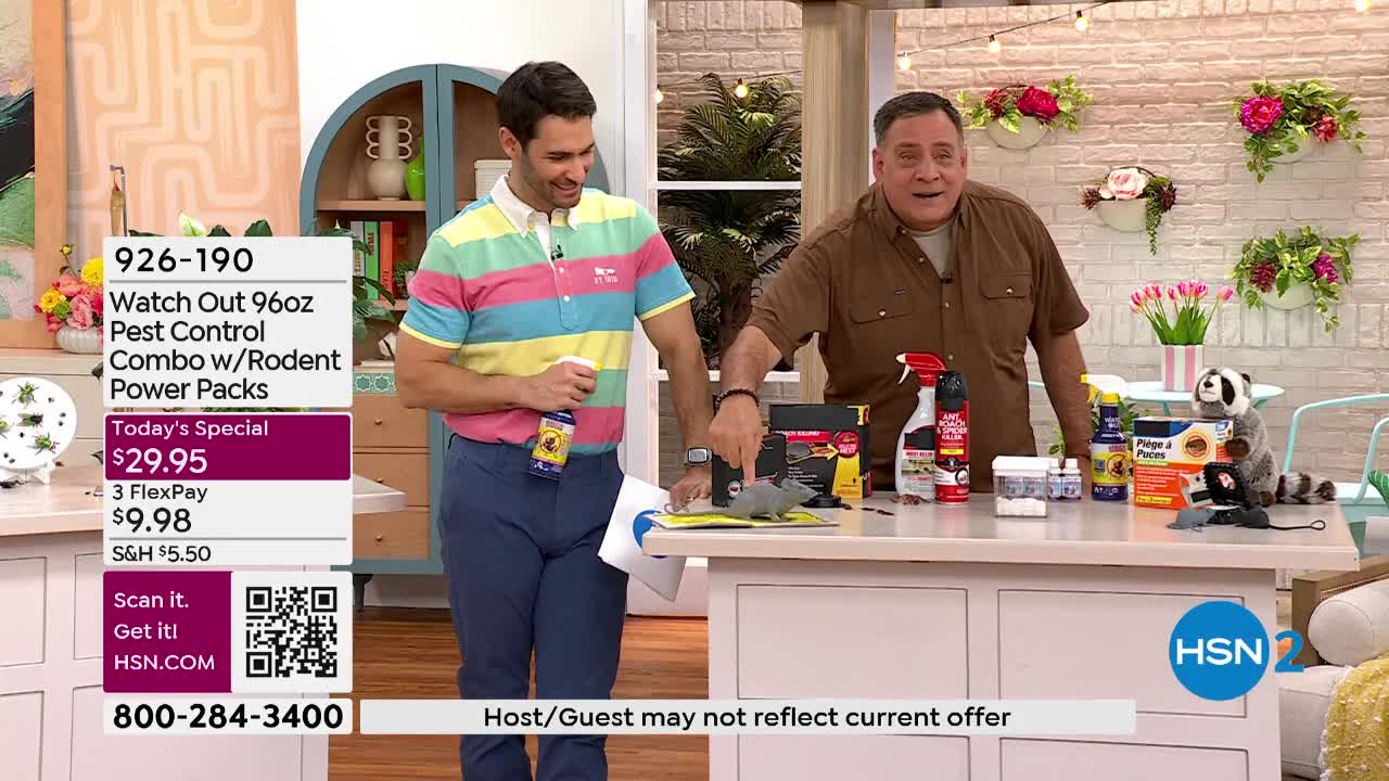 The man in the striped shirt is holding a spray can and demonstrating something on the table. Beside him, another man points at a grey, rodent-shaped object.