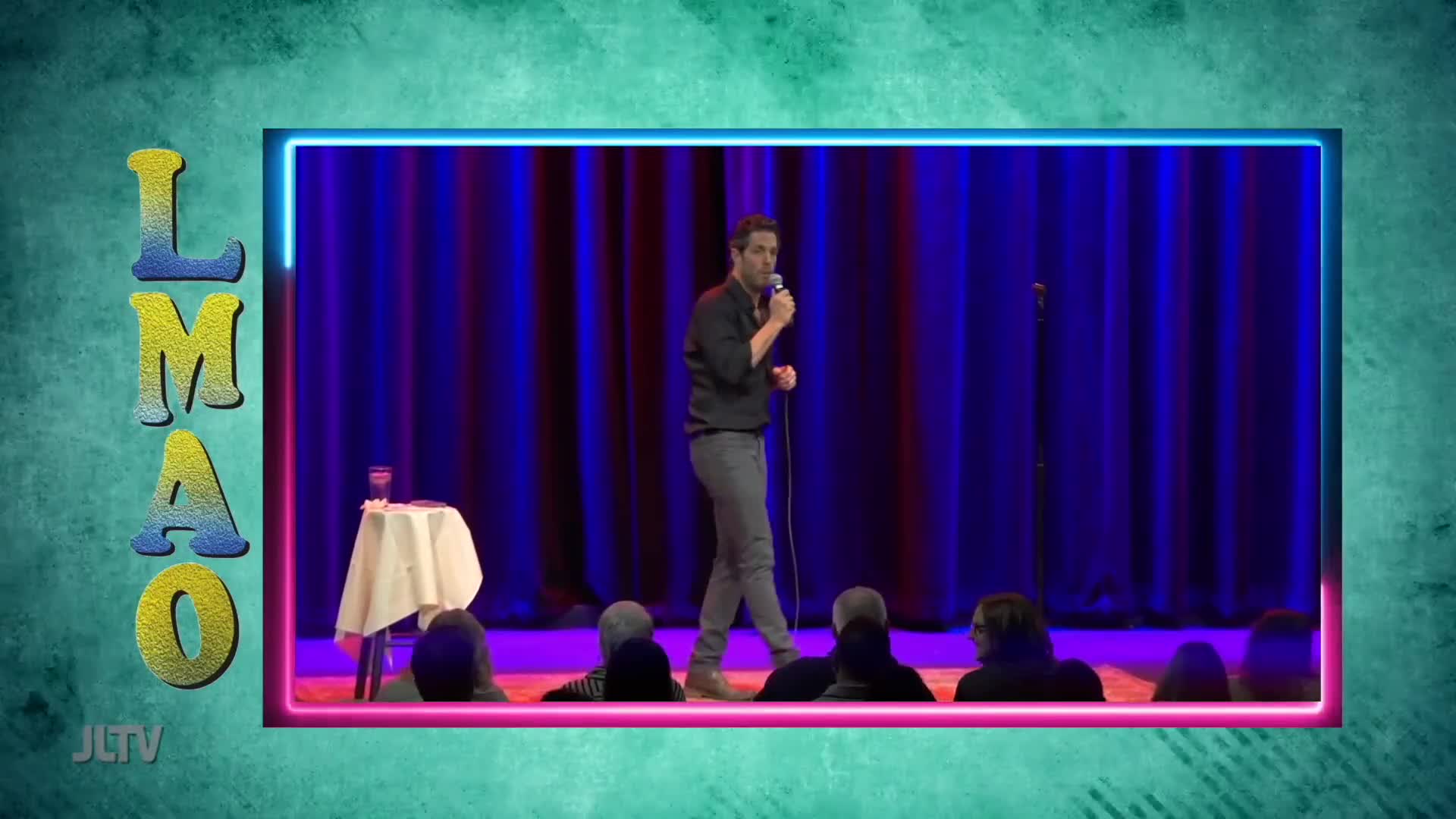 A comedian holds a microphone, mid-sentence, on a stage with deep blue curtains. The "LMAO" graphic and "JLTV" logo frame the performance.