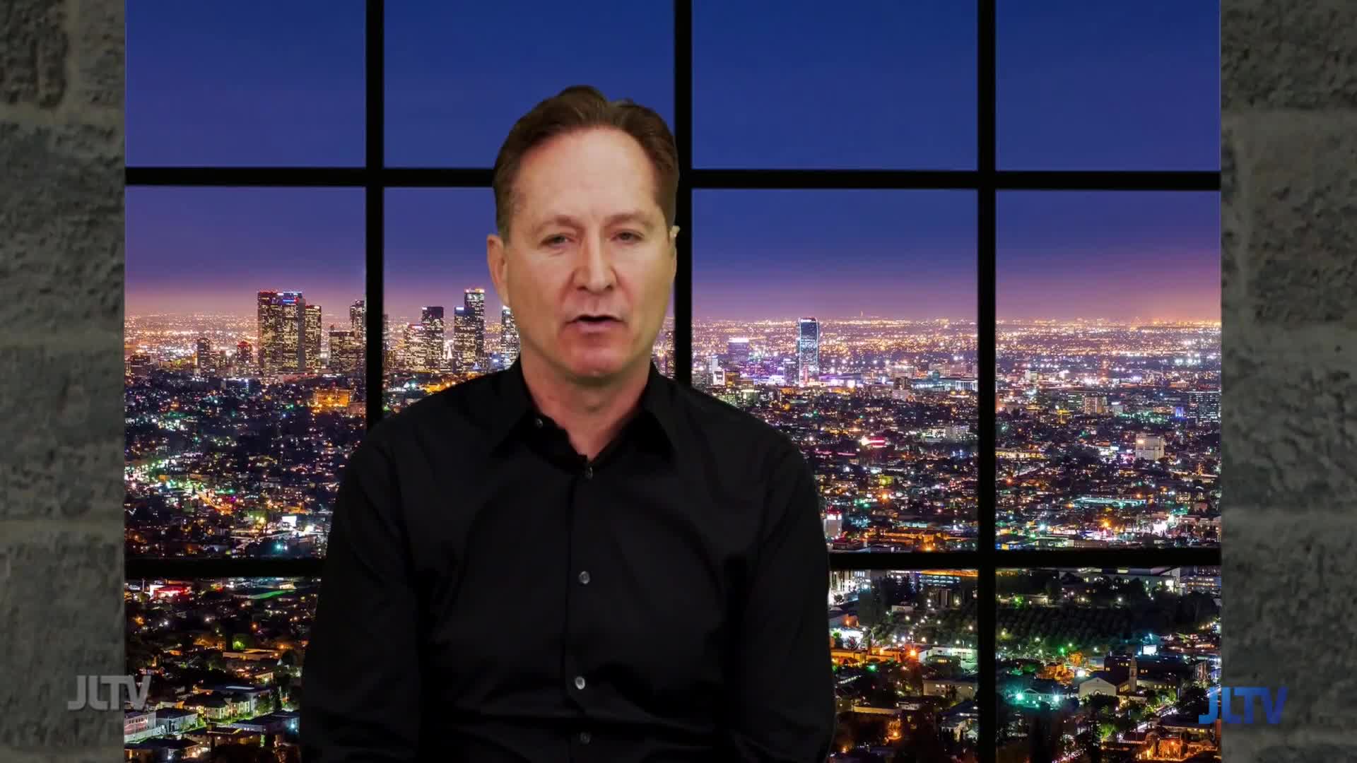 A man in a black shirt speaks directly to the camera, with a sprawling cityscape at dusk visible behind him. The lights of Los Angeles twinkle under a deep purple sky, a familiar backdrop for Jewish Life Television.