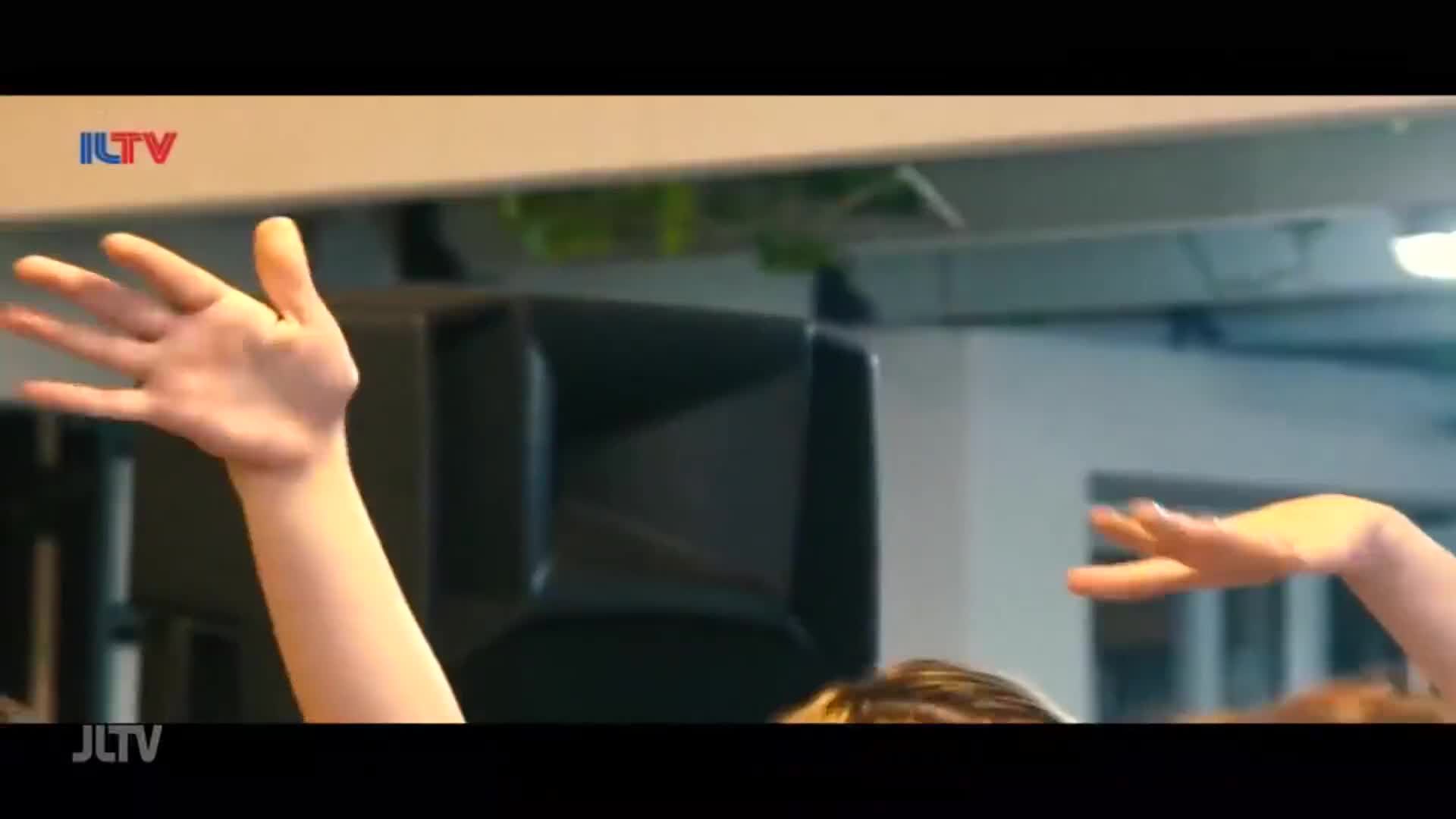 A hand with fingers splayed upward moves across the frame. Another hand, palm down, curves gracefully to the right.