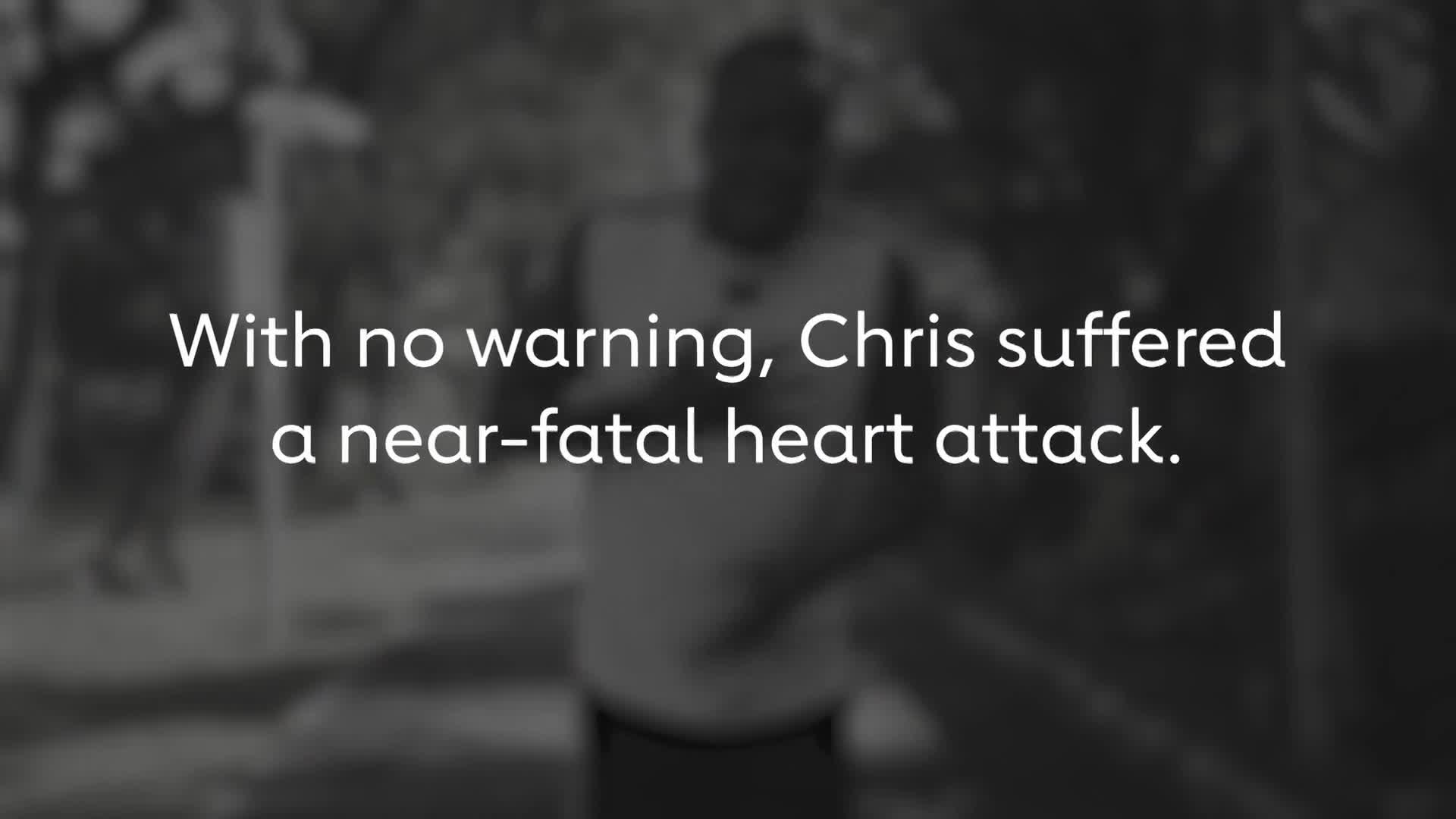 A man in a t-shirt stands in the background, his form indistinct. White text overlays the scene, stating, "With no warning, Chris suffered a near-fatal heart attack."