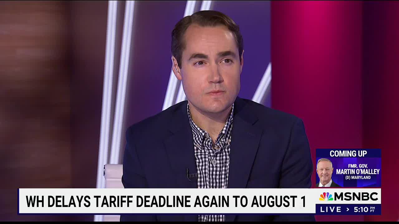 A man in a navy blazer and checkered shirt sits in a studio, looking directly at the camera. On the lower third of the MSNBC screen, a headline announces a delay in a tariff deadline.
