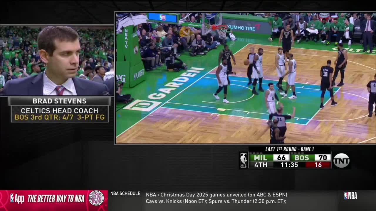 The Celtics' coach is being interviewed on NBA TV as the game continues. On the court, players in black and white jerseys are positioned, and a referee signals a call.
