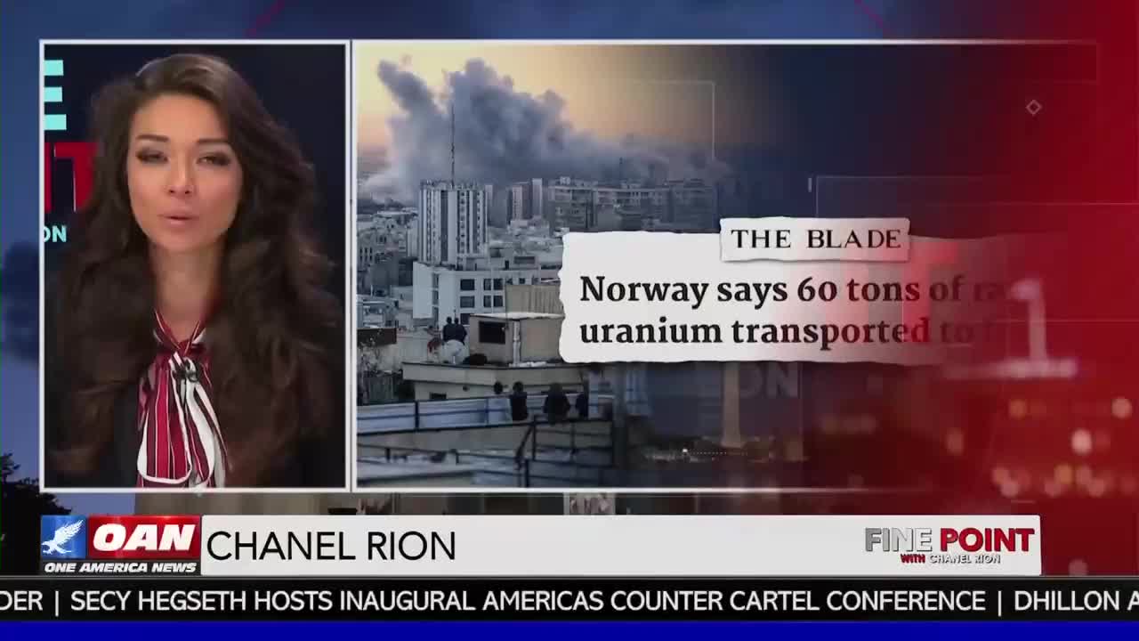 Chanel Rion reports on the news that Norway says 60 tons of uranium were transported. A plume of smoke rises over buildings in the background.