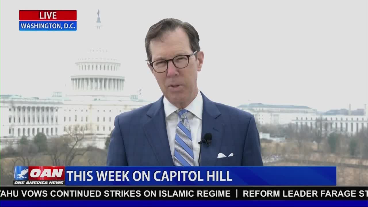 A man in a suit and tie stands before the Capitol building in Washington, D.C. A banner below him reads "THIS WEEK ON CAPITOL HILL" from One America News Network.