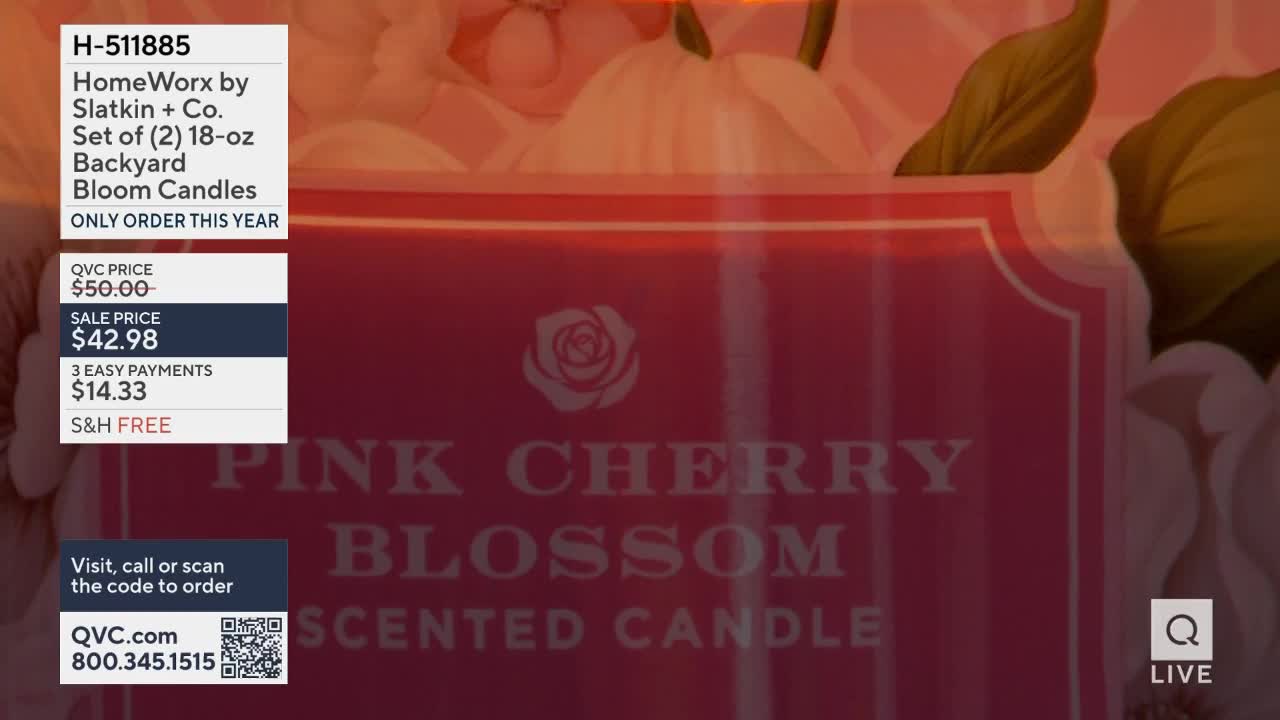 A large pink candle with "Pink Cherry Blossom Scented Candle" printed on it sits on display. A graphic overlays the candle, showing product details like the sale price of $42.98 and ordering information for QVC.