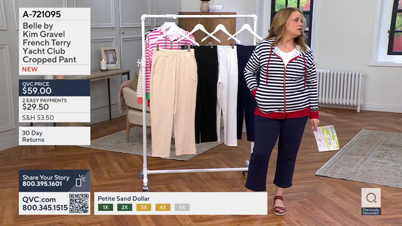 A woman in a striped jacket and navy pants stands near a rack of clothing. She holds a paper with colorful markings.